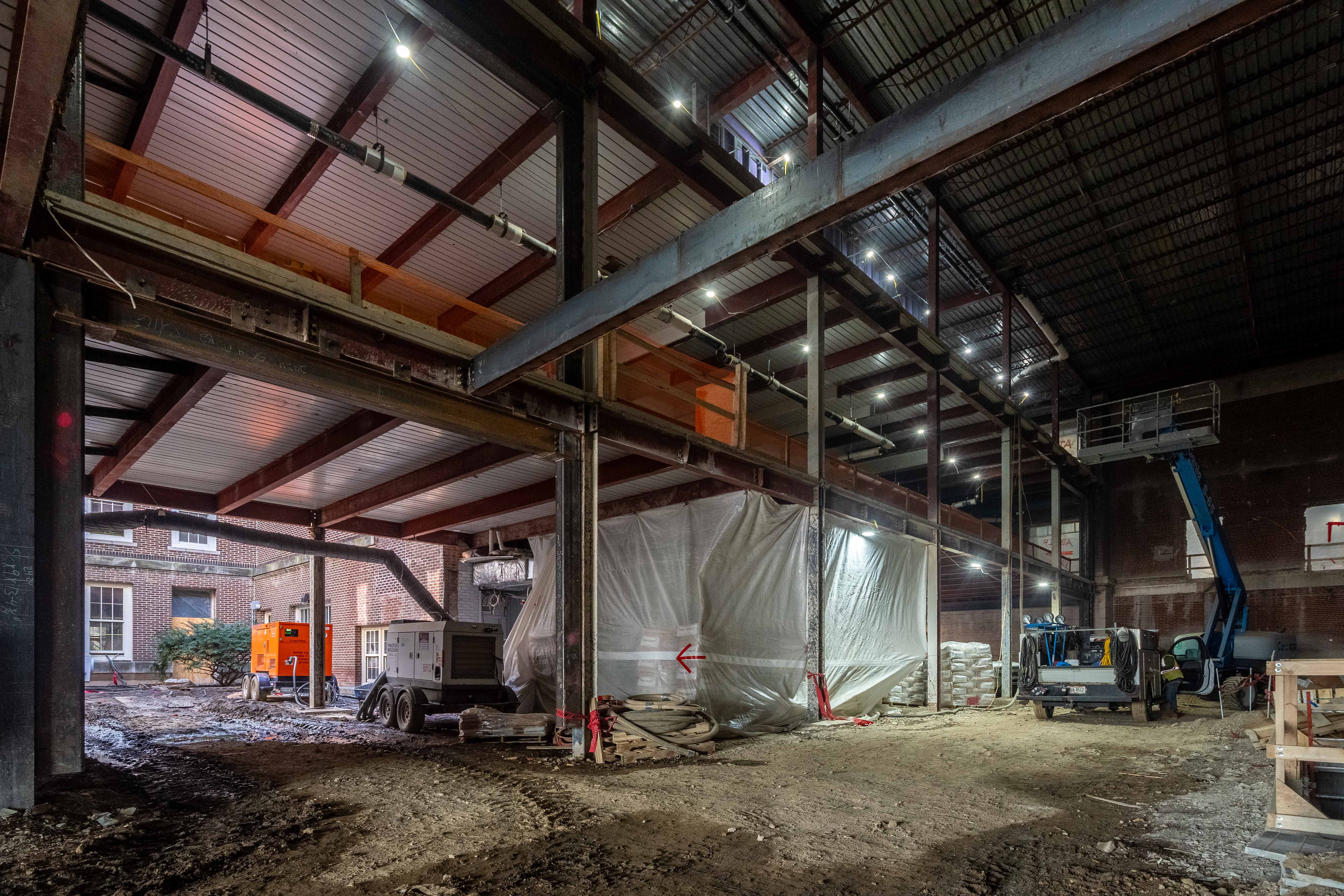 A view of a large, open area under construction with a dirt floor.