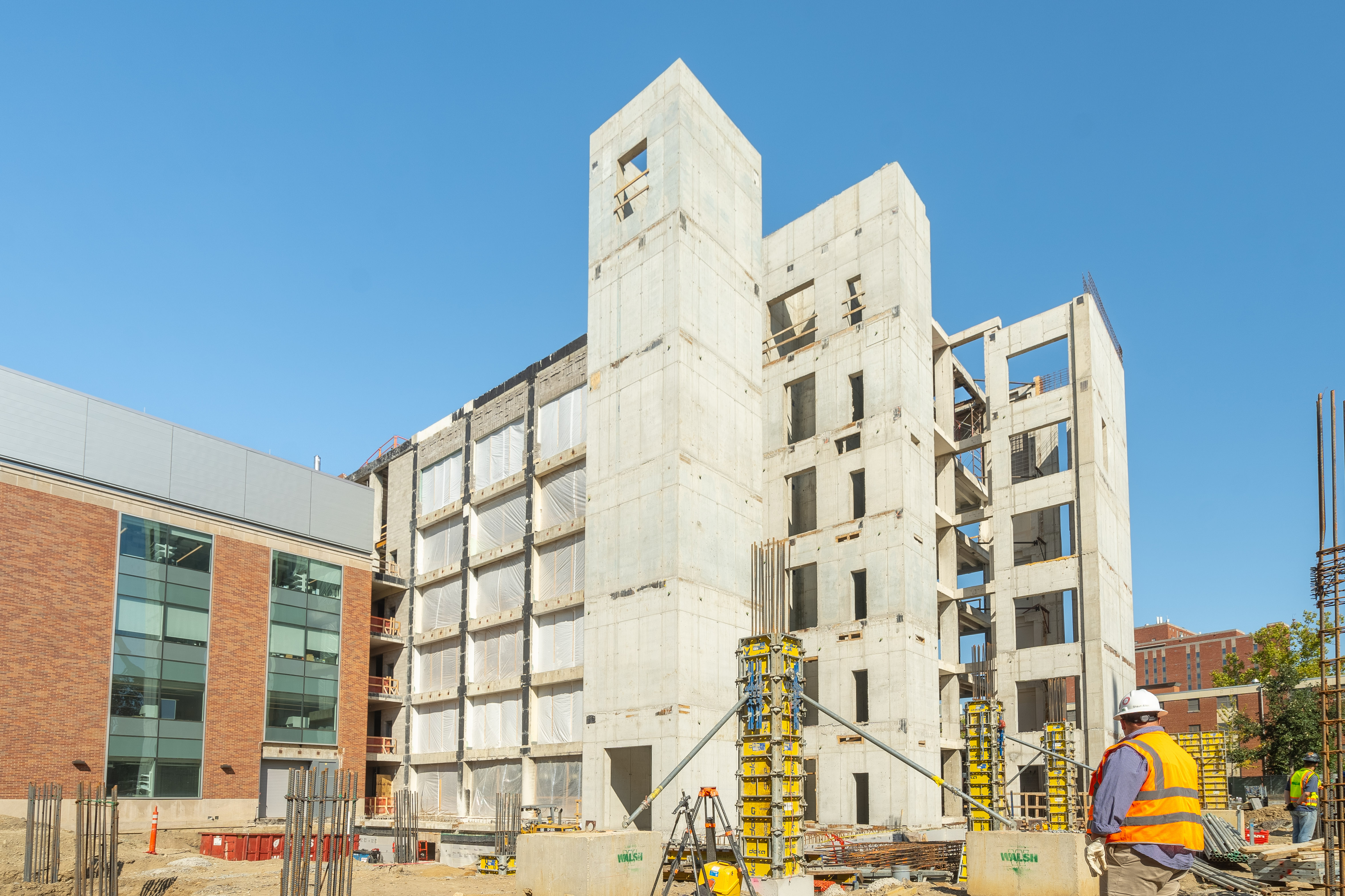 An exterior view of BMEC where a few crew members can be seen on the ground level working.