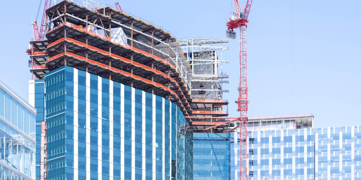 A view of the outside of the building where crews can be seen working on the exterior on a crane.