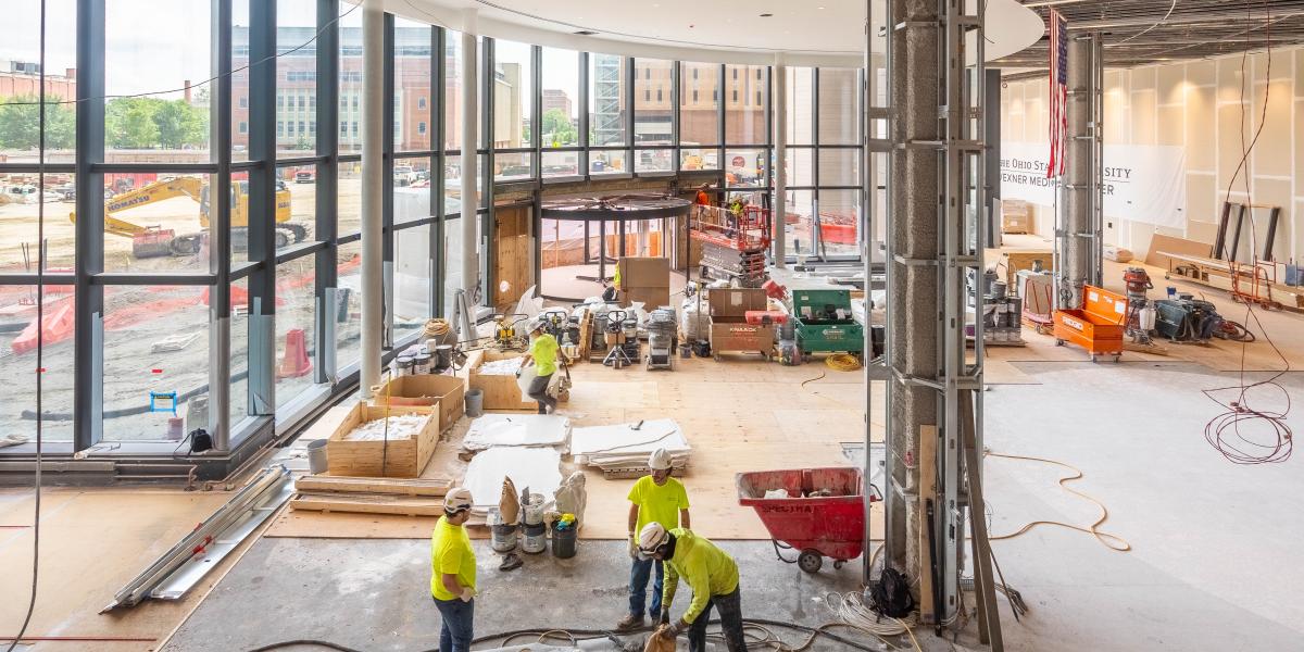 A view of the main lobby where crews are working to install flooring.